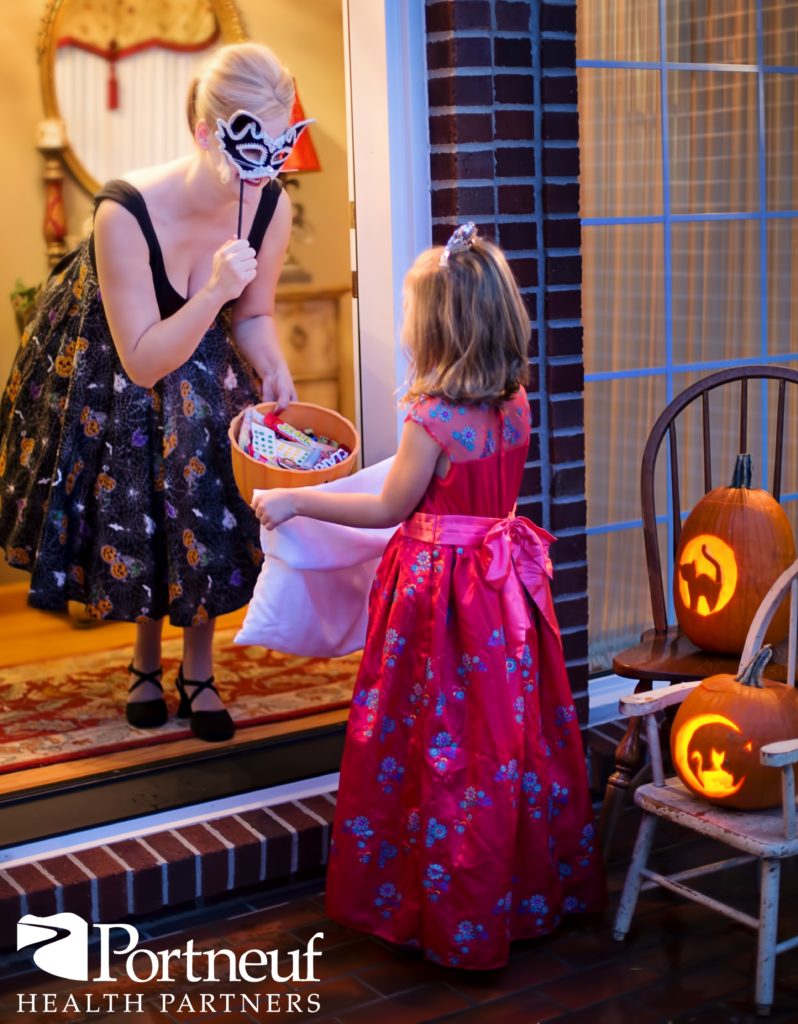 Photo of a little girl Trick or Treating at a home.