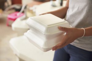 Hand holding leftover food boxes